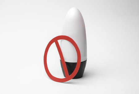 White antiperspirant tube stick with red prohibition sign on white backgroundの写真素材