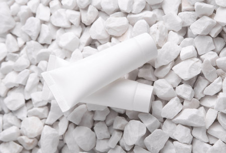 White cream tubes on pebbles close upの写真素材