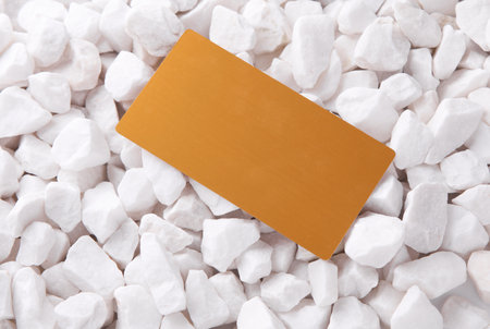 Golden business card on white pebblesの写真素材