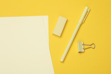 Yellow Stationery set with paper sheets on yellow background. Back to school, education, office supplies. Flat lay. Top view. Monochrome photo. Creative layoutの写真素材