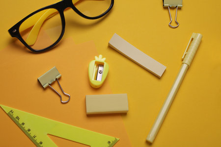 Yellow Stationery set on yellow background. Back to school, education, office supplies. Monochrome photo. Flat lay. Top view. Creative layoutの写真素材