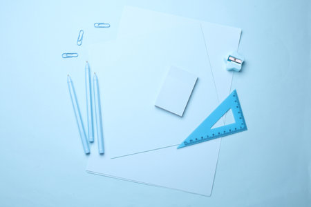 Blue Stationery set on light blue background. Back to school, education, office supplies. Monochrome photo. Flat lay. Top view. Creative layoutの写真素材