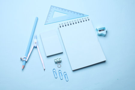 Blue Stationery set on light blue background. Back to school, education, office supplies. Monochrome photo. Flat lay. Top view. Creative layoutの写真素材