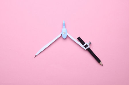 Drawing compass on a pink backgroundの写真素材