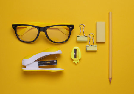 Yellow Stationery set on yellow background. Back to school, education, office supplies. Monochrome photo. Flat lay. Top view. Creative layoutの写真素材
