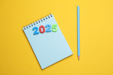 2025 year text with multicolored numbers and notebookの写真素材