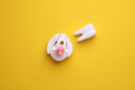Rubber unicorn with tooth on yellow backgroundの写真素材