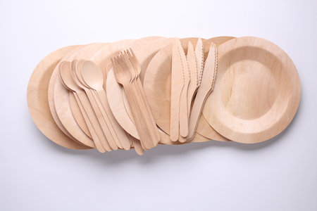 Set of wooden eco dishes on a white background. Plates, forks, knives and spoonsの写真素材