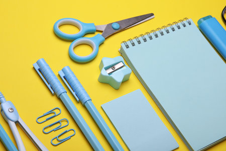Blue Stationery set on yellow background. Back to school, education, office supplies. Flat lay. Top view. Creative layoutの写真素材