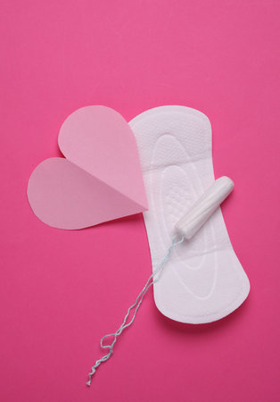 Pad with tampon and heart on pink background. Menstruation, critical days, female menstrual cycleの写真素材