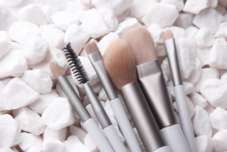 Set of makeup brushes on white pebblesの写真素材