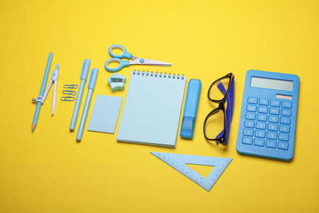 Blue Stationery set on yellow background. Back to school, education, office supplies. Flat lay. Top view. Creative layoutの写真素材
