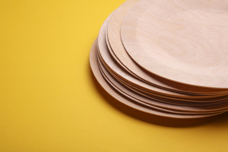 Eco wooden plates on yellow backgroundの写真素材