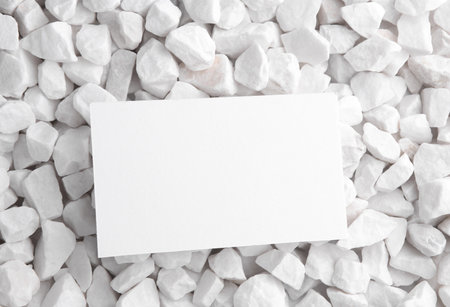 White card close up on pebbles. Mockup for designの写真素材