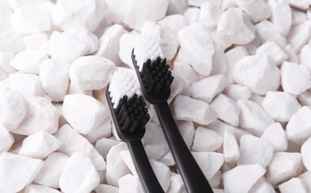 Plastic toothbrushes on a white pebblesの写真素材