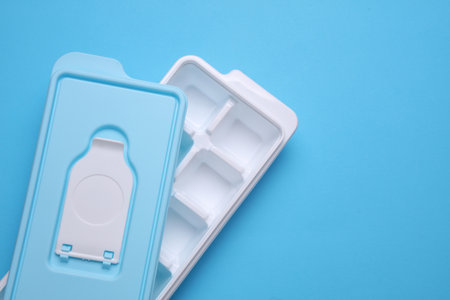 Plastic Ice Cube Maker Tray on Blue Backgroundの写真素材