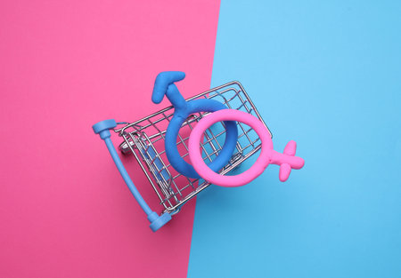 Supermarket trolley with female and male gender symbols on blue pink backgroundの写真素材