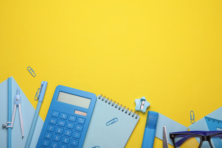 Blue Stationery set on yellow background. Back to school, education, office supplies. Flat lay. Top view. Creative layoutの写真素材