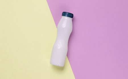 Yogurt bottle on pastel paper background. Top view