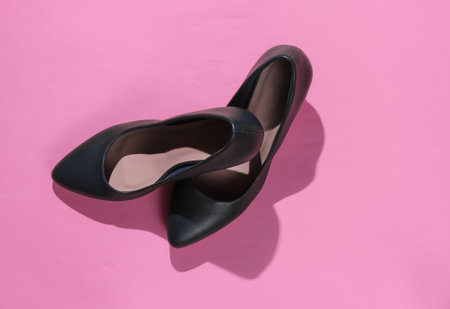 Classic women's high heel shoes on pink paper background. Stylish shoes. Studio shot. Minimalistic...
