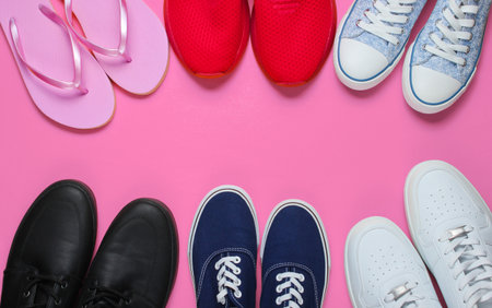 Lot of pairs of shoes on pink background. Minimalistic fashion concept. Top view. Copy spaceの写真素材