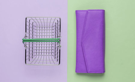 Minimalistic shopping concept. Mini shopping basket and red leather wallet on pink green background. Top viewの写真素材