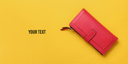 Red leather wallet on yellow background. Top view. Copy spaceの写真素材