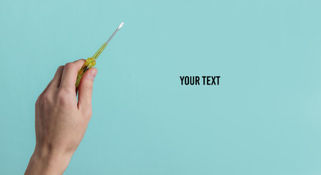 Repair concept. Female hand holds a screwdriver on a blue studio background. Copy space