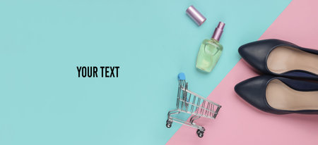 Shopping concept. High-heeled shoes, shopping trolley, perfume bottle on a pink-blue background. Copy space
