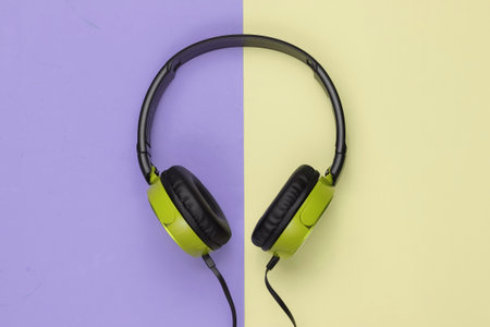 Modern wired headphones on colored pastel background. Music lover concept. Top view