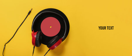 Wired headphones with a vinyl record on yellow background with space for text. Retro style, DJ. Top...