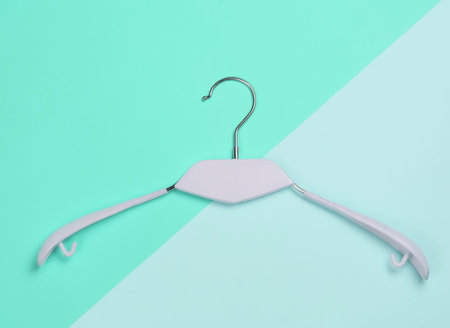 Clothes hanger on blue background. Minimalistic fashion concept. Studio shot. Top viewの写真素材