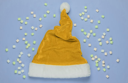 Santa hat and marshmallows on a blue background. Top view. Studio shot.の写真素材