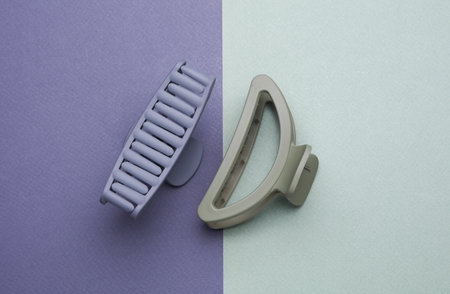 Plastic hair clips isolated on purple green background
