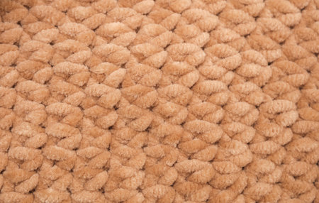 Texture of beige knitted yarn close-up