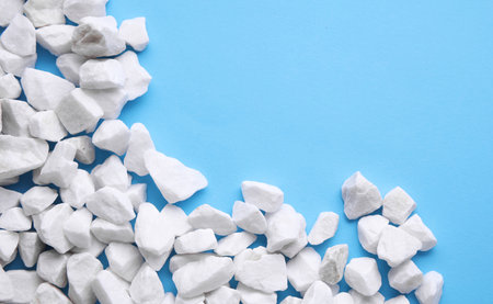 White pebbles on a blue background. Copy space