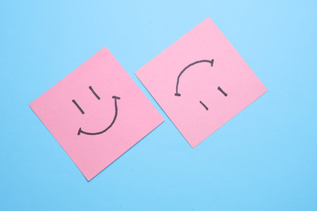 Happy faces on square memo papers, blue background. Business concept