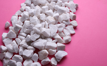 White pebbles on a pink background.