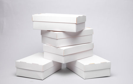 Stack of White cardboard boxes on a gray background