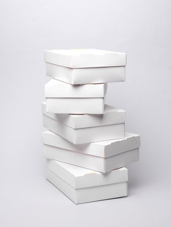 Stack of White cardboard boxes on a gray background