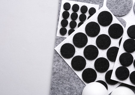 Felt protective circle pads for furniture on gray background