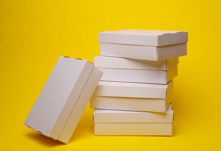 Stack of White cardboard boxes on a yellow background