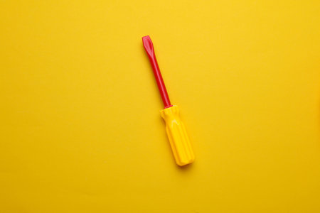 Children's toy screwdriver on a yellow backgroundの写真素材