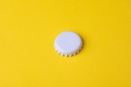 White metal bottle cap mockup on yellow backgroundの写真素材