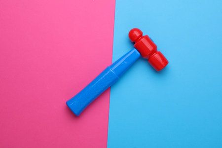 Children's toy hammer on a pink blue backgroundの写真素材
