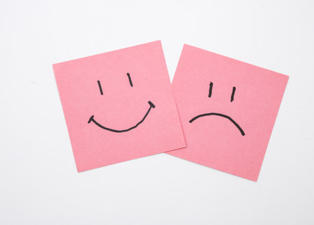 Happy and unhappy faces on square memo papers, white background. Business concept