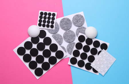 Felt protective circle pads for furniture on pink blue background