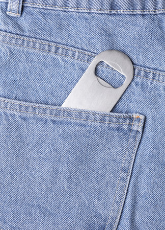 Beer opener in the pocket of blue jeans