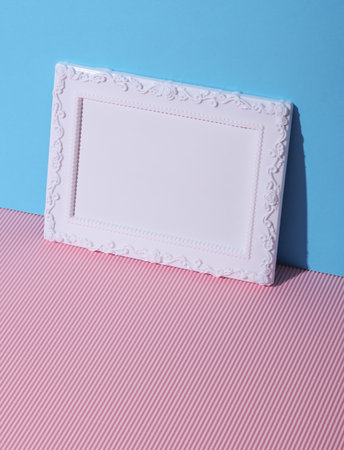 Ornamental blank photo frame on pink blue background