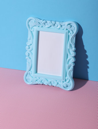 Ornamental blank photo frame on pink blue backgroundの写真素材